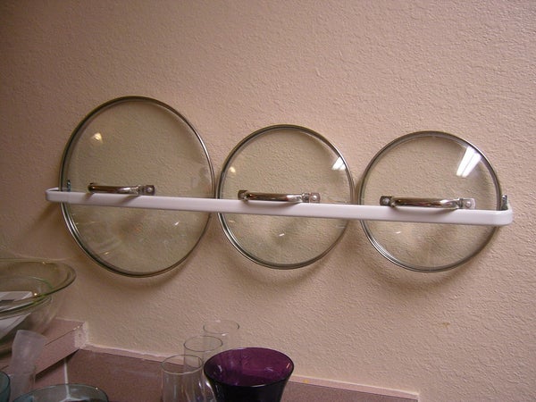 Hang a long towel bar to store pot lids and other hangable items