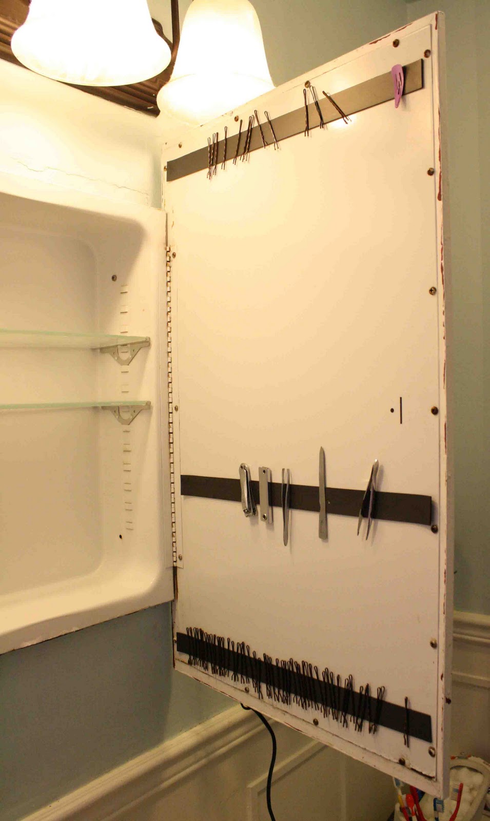 Attach a magnetic strip to the inside of your medicine cabinet door