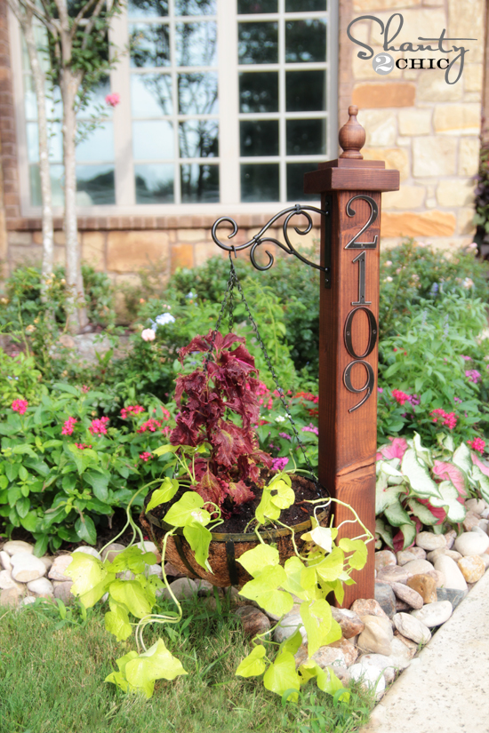 Attach numbers to a wooden post and hang a basket of flowers